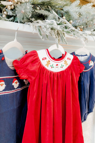 Red dress with white embroidery on a hanger in front of Christmas tree. Whatsoever Things | Dallas, TX