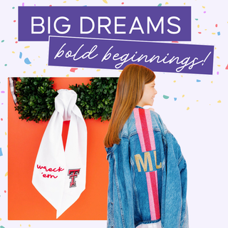 Promotional banner for a Graduation Collection with a woman wearing a jacket with 'MJ' on it, standing next to a white sash with 'Wreck Em' text, against an orange background with text about personalized gifts | Whatsoever Things | Dallas, TX