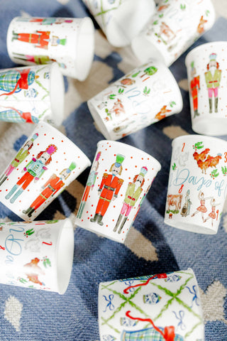 Set of paper cups with festive designs on a blue textured surface. | Whatsoever Things | Dallas, TX | Personalized Apparel, Decor and Gifts for Men and Women | Embroidery and Monogramming 