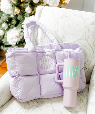 Purple quilted bag and pink mug with 'JM' monogram on a white surface with Christmas tree in the background. Whatsoever Things | Dallas, TX | Personalized Apparel and Home Decor for Women and Children 