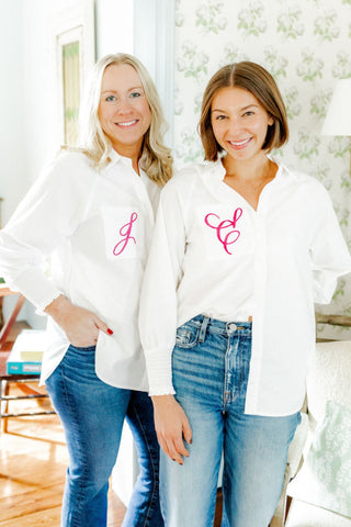Two women wearing white shirts with pink monograms in a bright room. Whatsoever Things, Dallas, TX | Customized Decor, Apparel and Gifts for Women and Children 