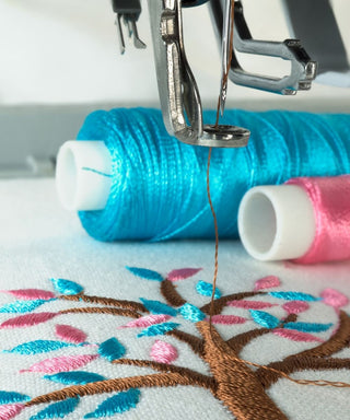 Sewing machine with brown blue and pink embroidery thread 